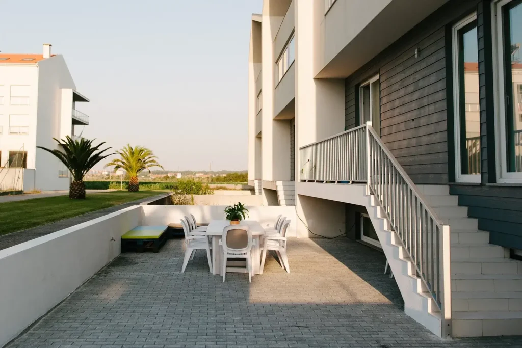 The backyard of the Secret Surf guest house with white table and chairs.