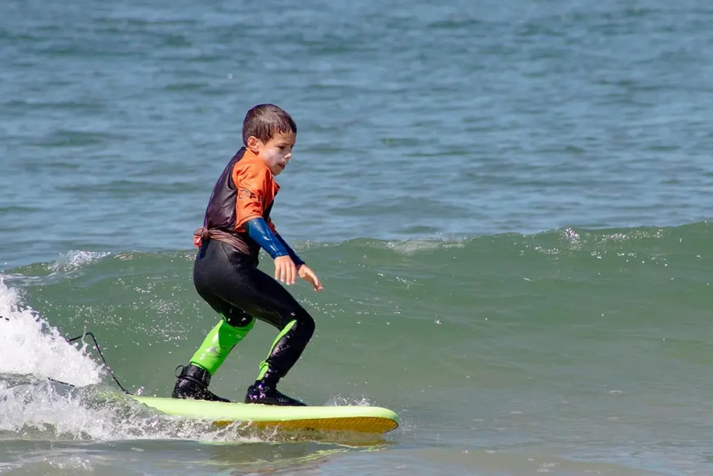 Child surfing down the wave at Barra Beach