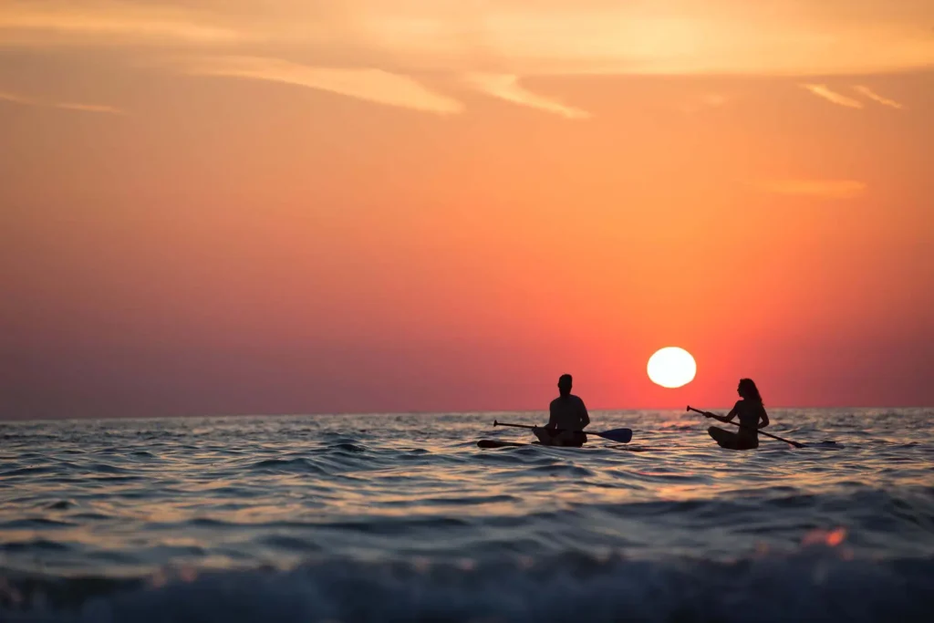 Beautiful sunset image of two paddle surfers on the water