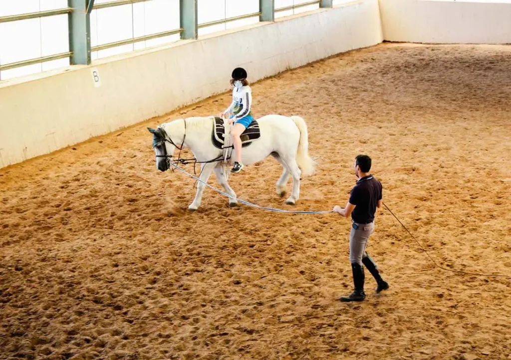 Surf Clinic horse riding for kids with an instructor guiding.